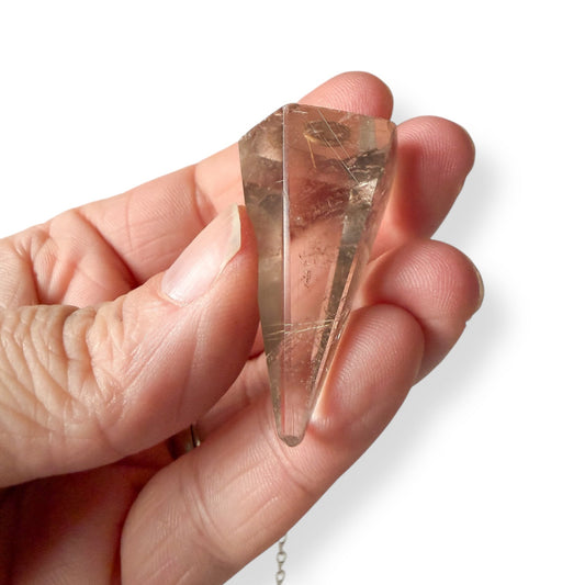 Close-up of smoky golden rutile quartz pendulum highlighting golden rutile threads