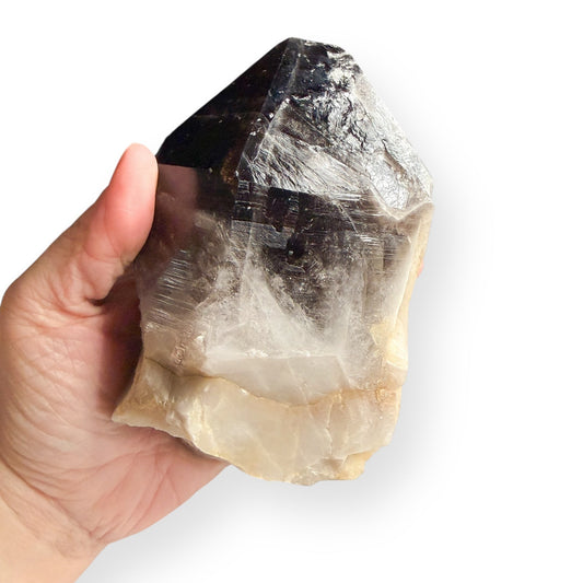 Large smoky quartz point held in hand for size reference