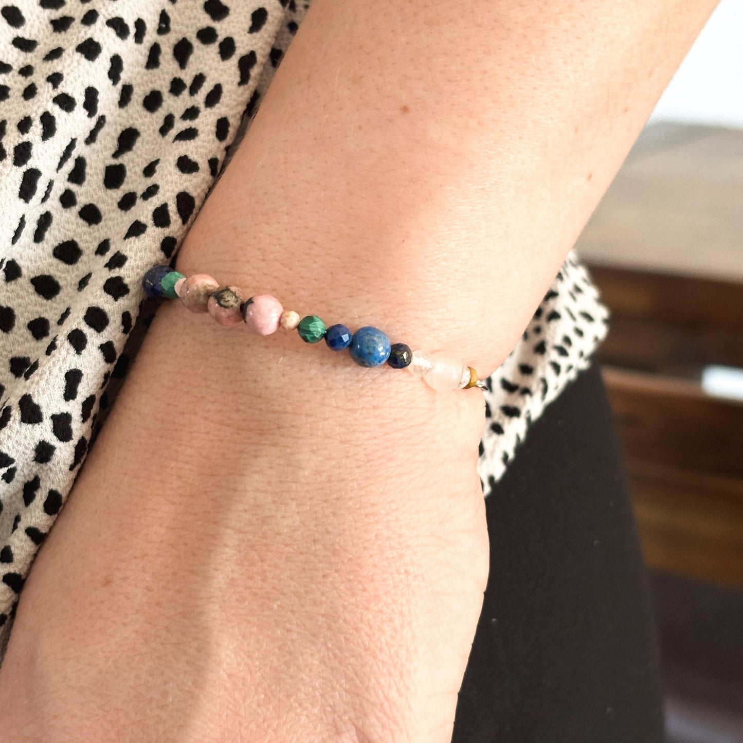 Taurus Crystal Charm Bracelet with a black charm worn on wrist, showcasing its flexible fit and natural tones.