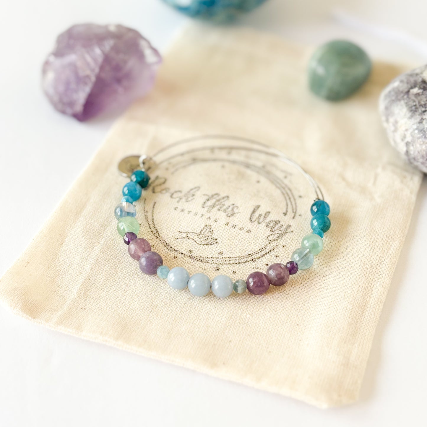 Flat lay of bracelet with serene props like crystals