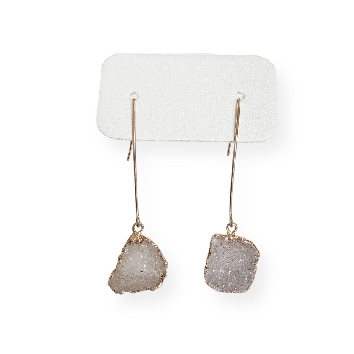 Close up of white squoval freeform drusy crystal earrings showing natural texture and sparkling crystal surface in gold filled setting