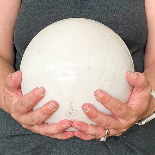 White marble sphere displayed upright with soft glossy finish