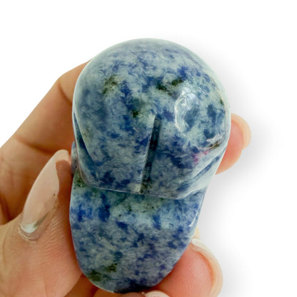 Bonham view of a hand carved sodalite skull in hand to show detail and size.