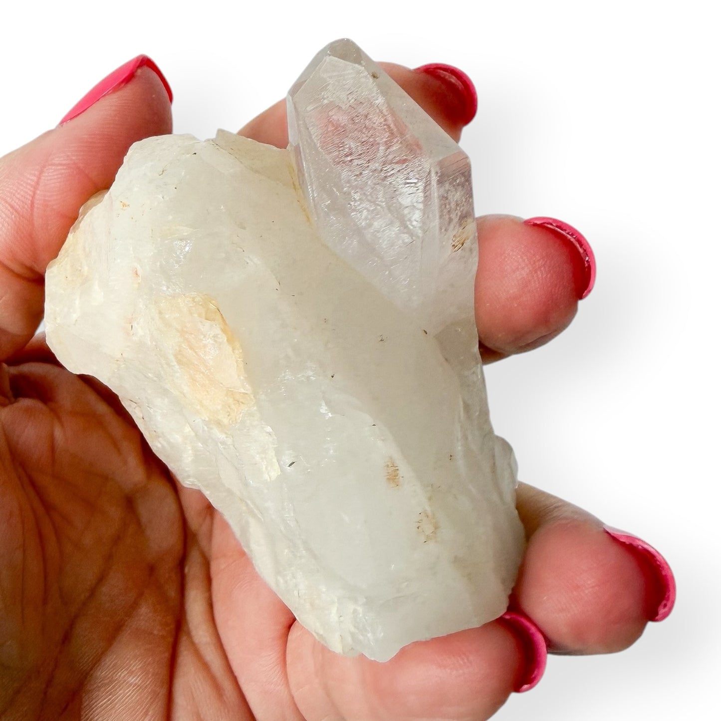 Hand holding a clear crystal rock against a white background