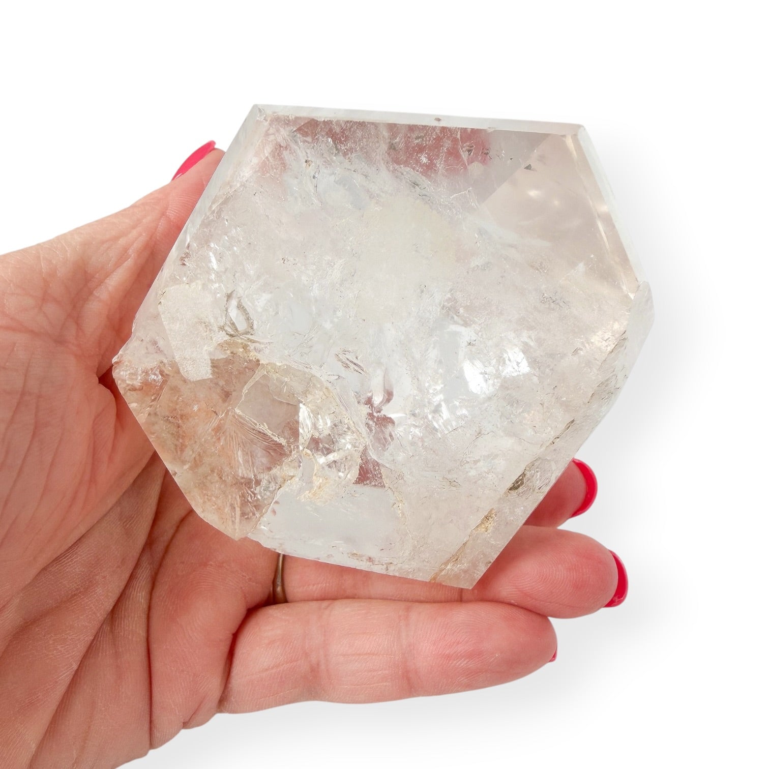Hand holding clear quartz tower showing the details of the base. 
