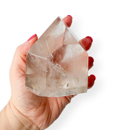 Clear quartz tower in hand showing size and details.