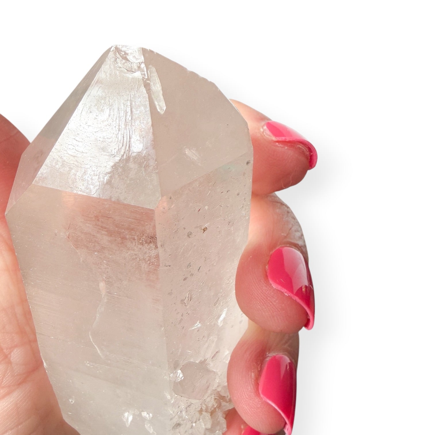 Person holding a clear quartz point giving a close up of the chipped point. 