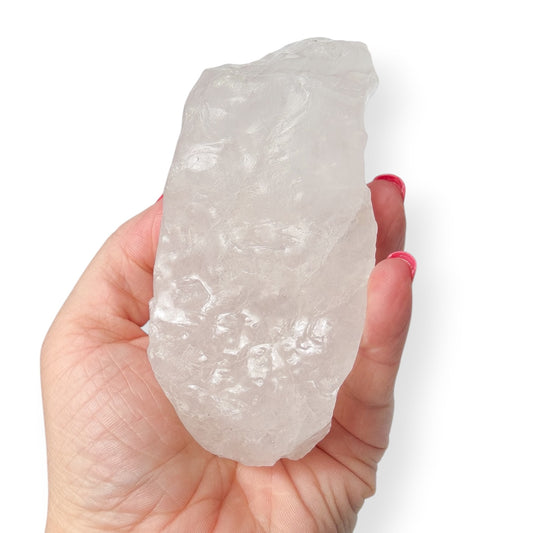 Hand holding a large white calcite crystal rock against a white background