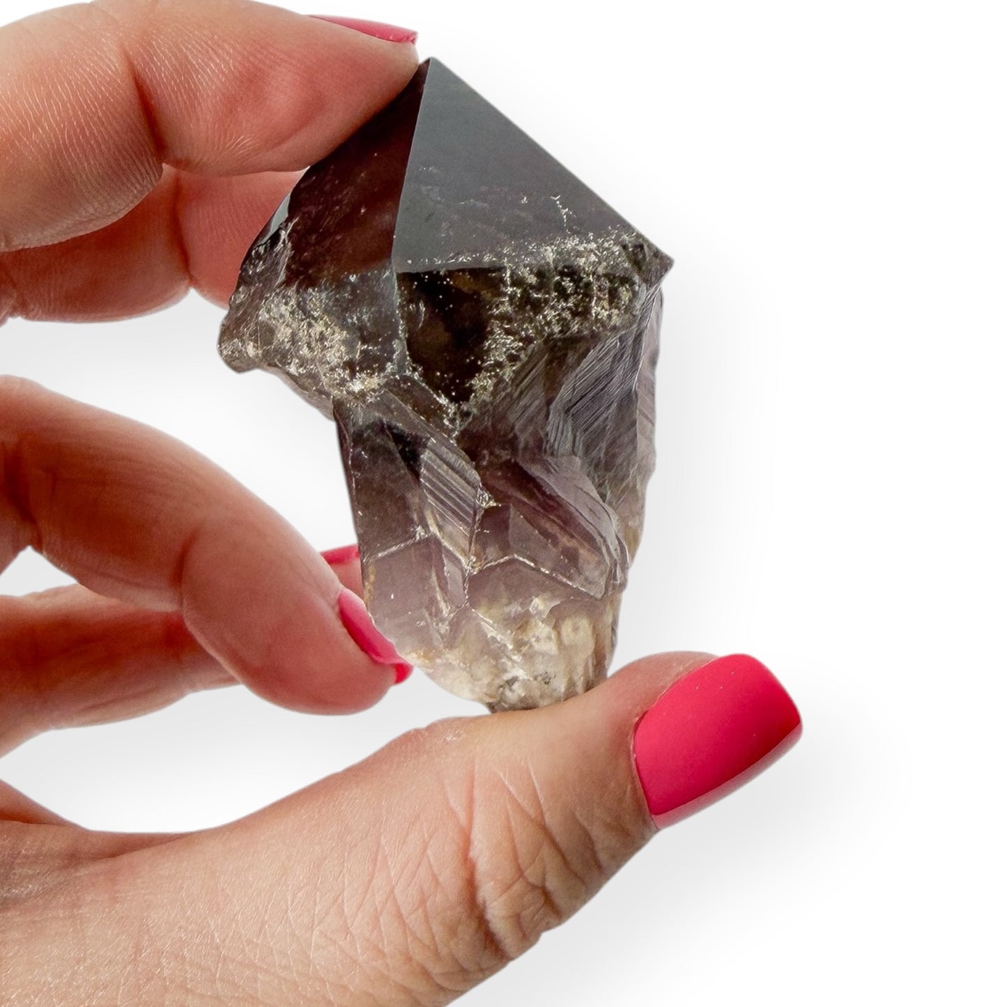 Side view of deep purple chevron amethyst in hand showing its natural details