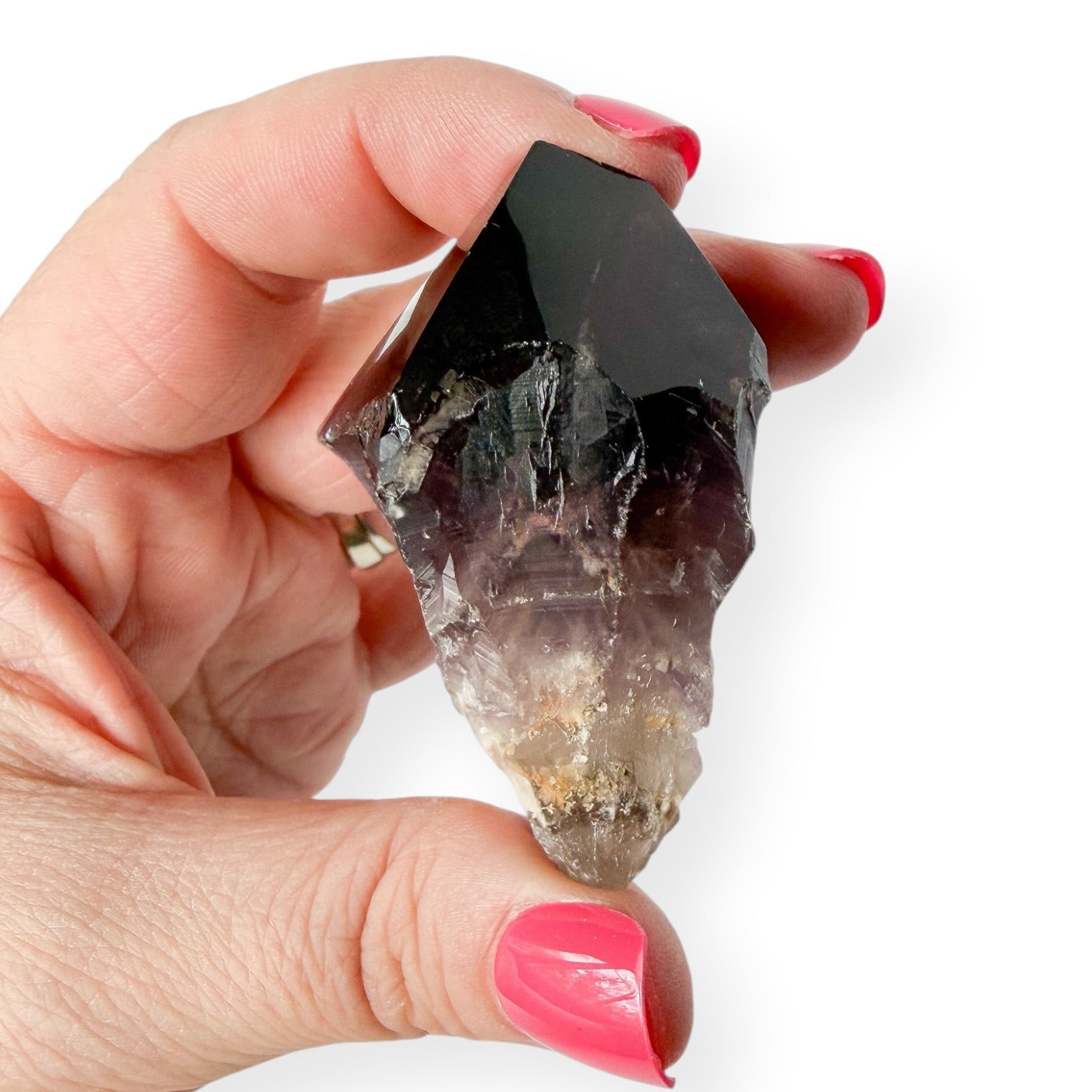 Size and details shown in a woman's hand of a deep purple chevron amethyst point.