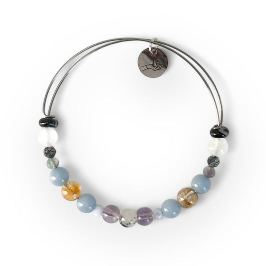 A multicolored beaded bracelet with a metal charm, displayed against a white background.