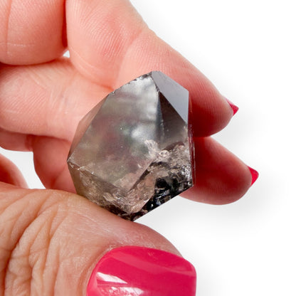 Garden quartz lodolite upclose view of point in hand. 