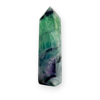 Green and purple fluorite obelisk on a white background