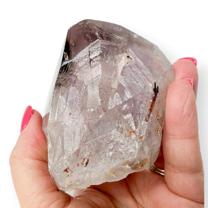 Woman holding Amethyst Purple Crystal showing details of crystal and size.
