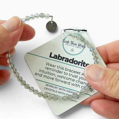 Labradorite bracelet with packaging in hand, showing how it stretches.
