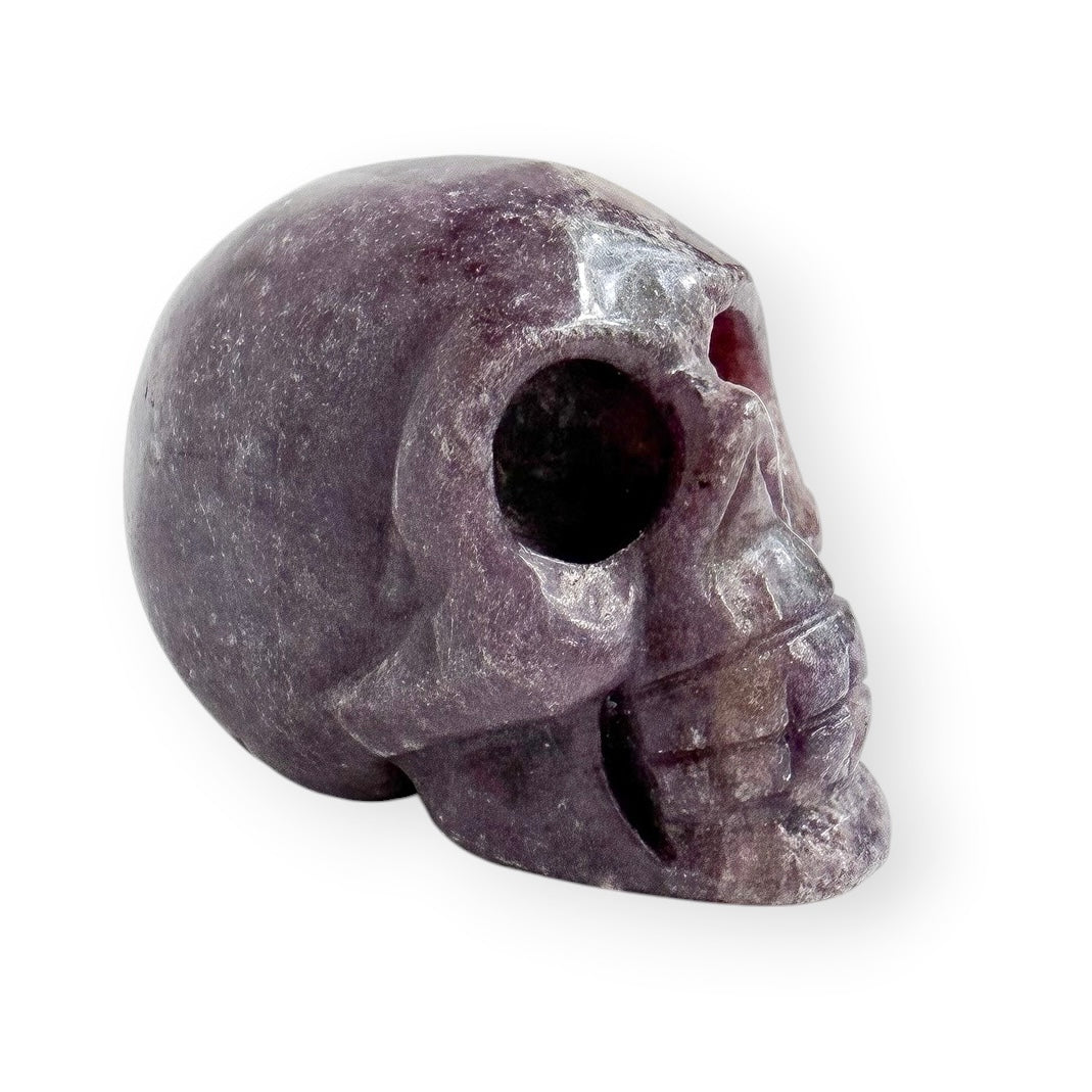 Hand carved lepidolite skull with a white background.