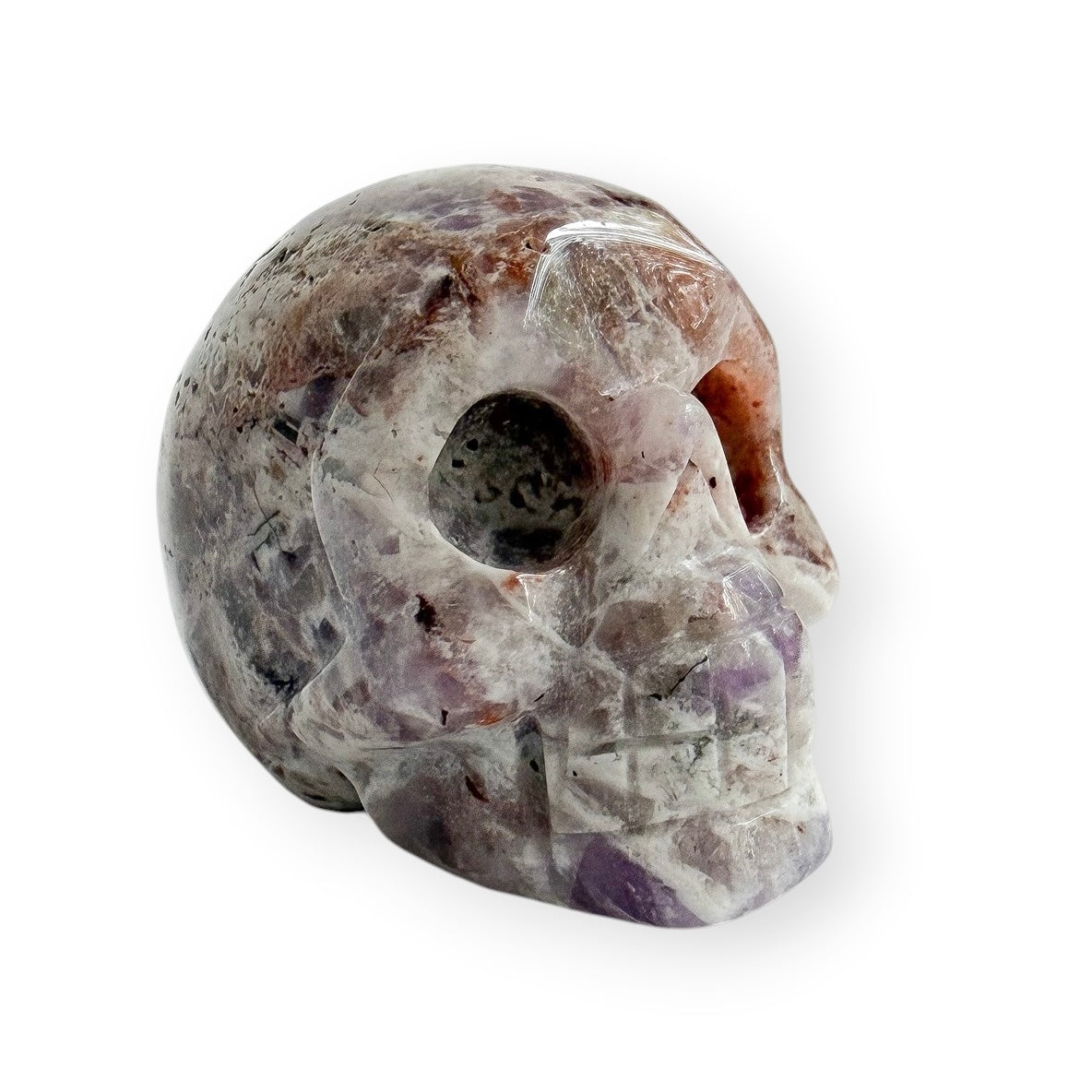 Hand carved light lepidolite skull with a white background.