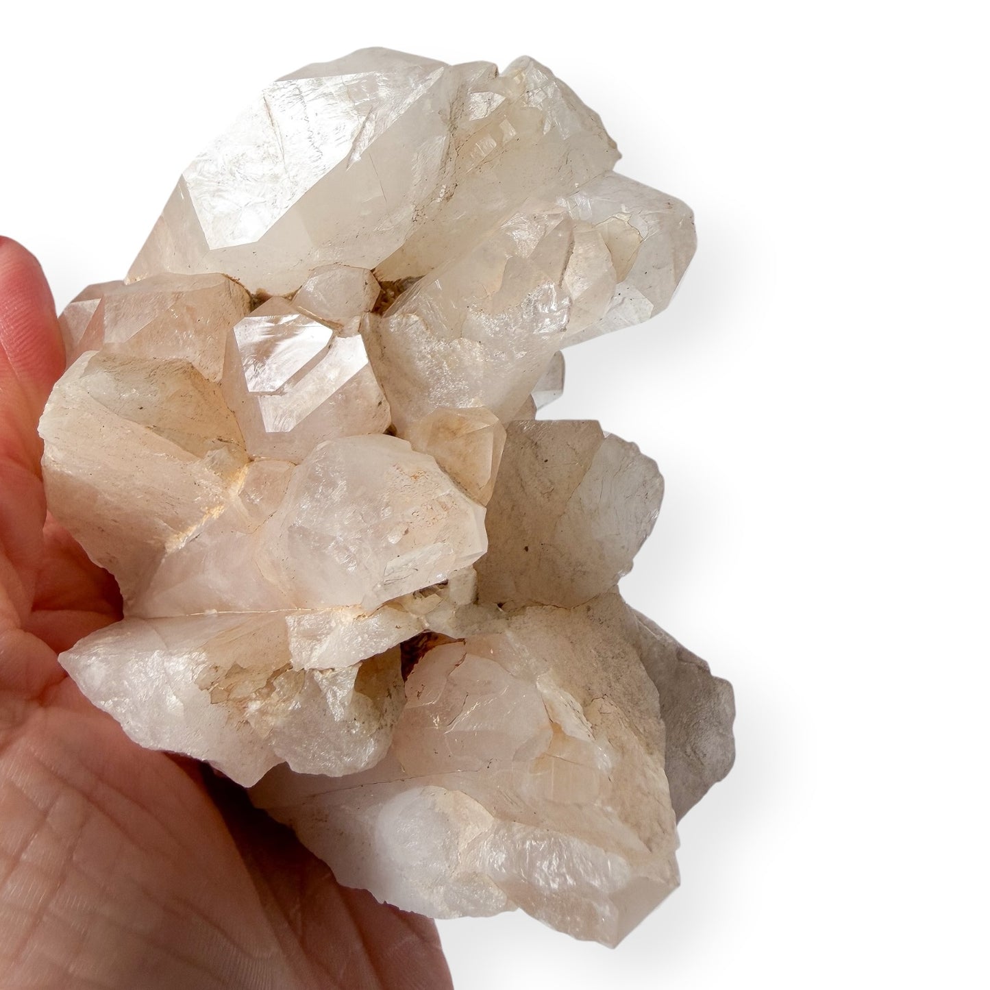 Hand holding a cluster of crystal rocks against a white background