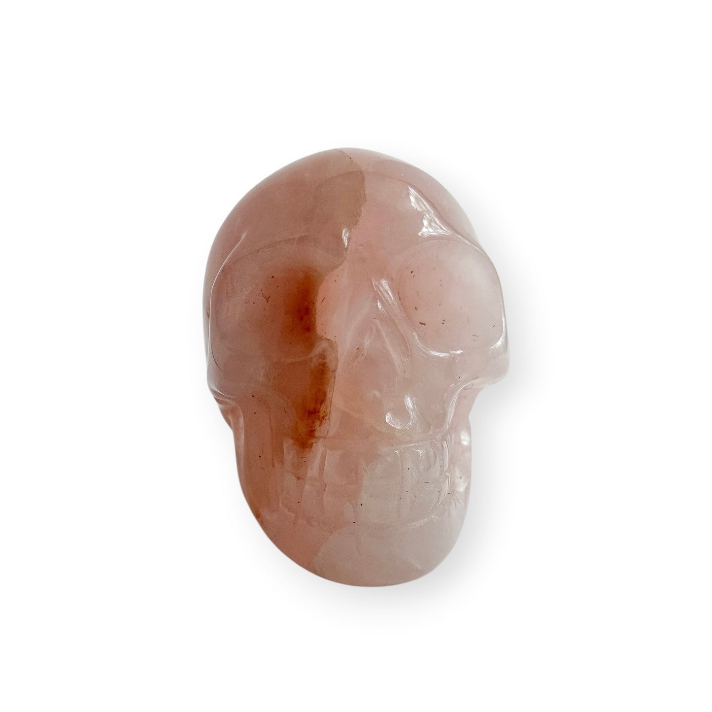 Hand carved rose, quartz skull on a white background.