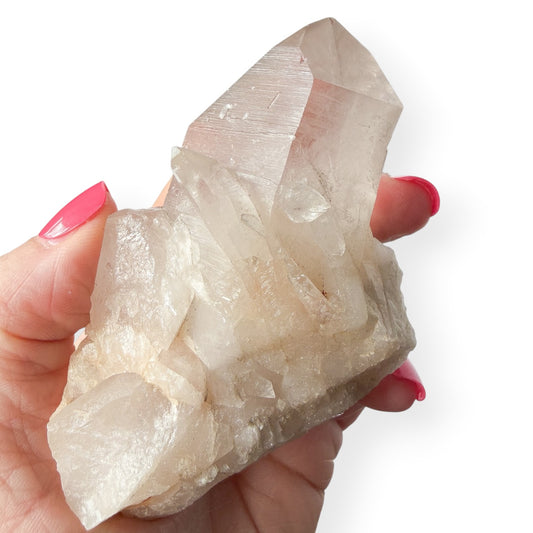 Hand holding a large self-healed clear quartz crystal with a white background