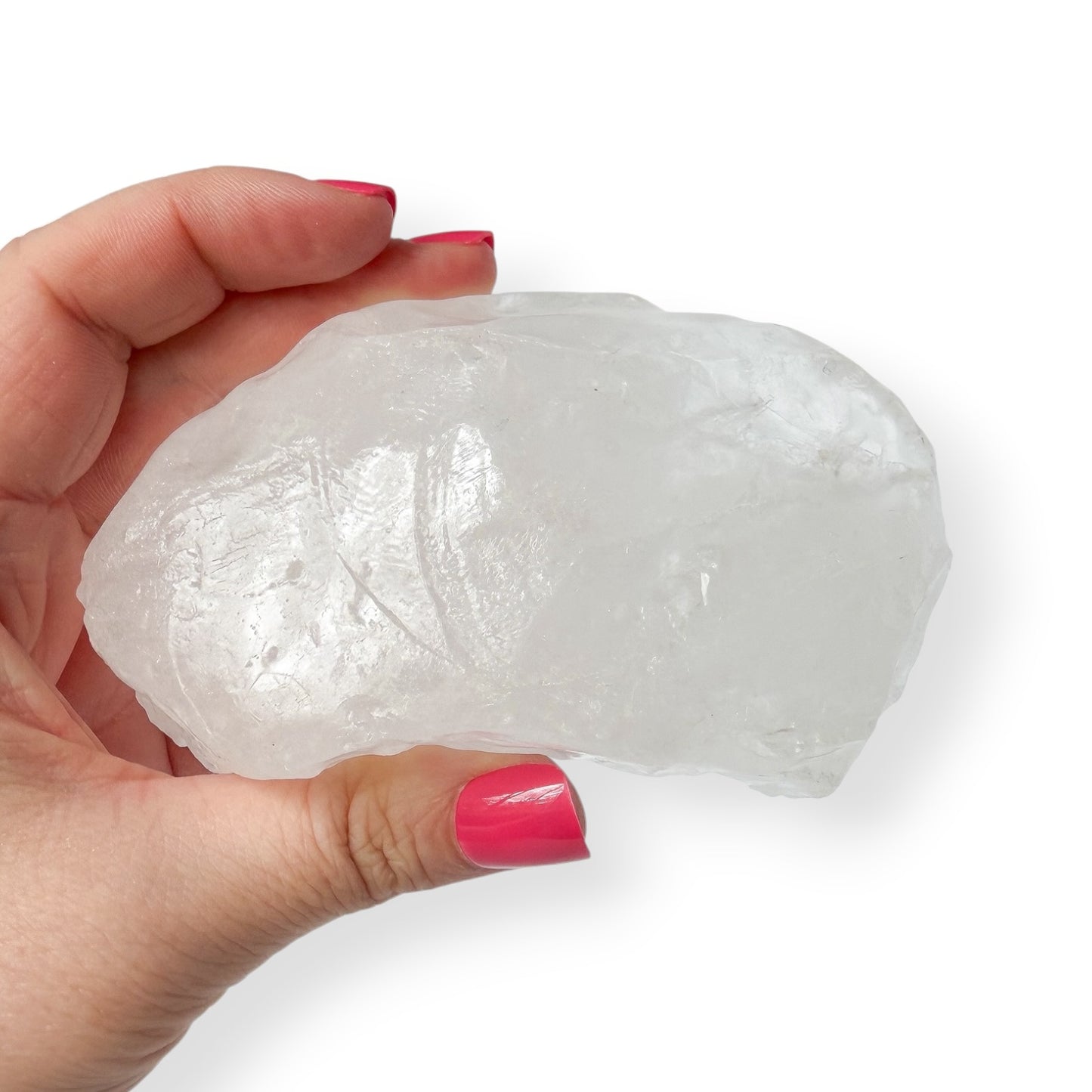 Hand holding a large white calcite crystal rock against a white background