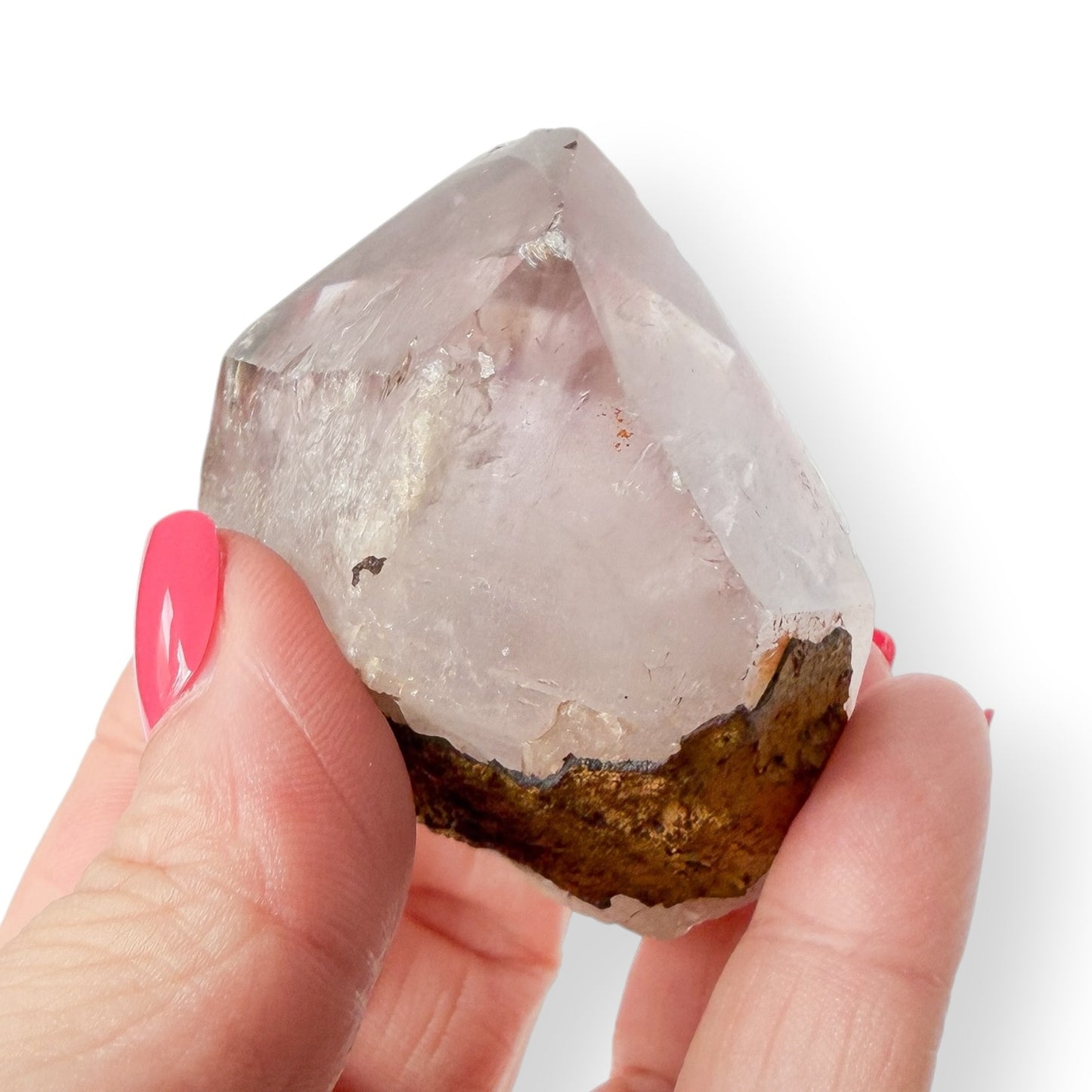Hand holding an Amethyst crystal with a white background
