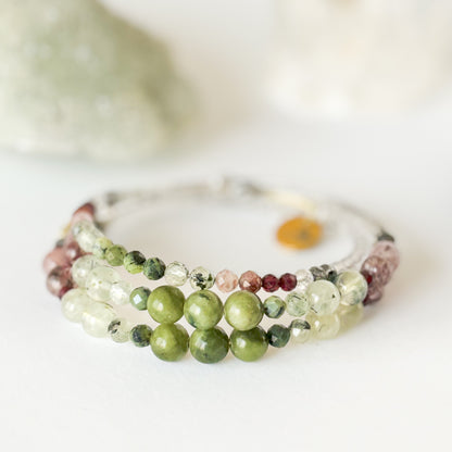 Flatlay of Tenacious Wrap Bracelet showing blend of green, pink, and deep red crystal beads.