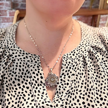 Full view of amethyst slice pendant necklace with silver setting and textured crystal core.