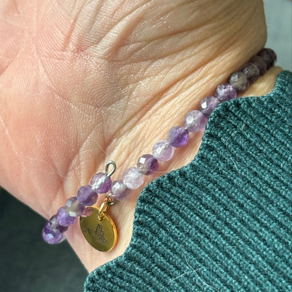 Amethyst wrap bracelet glowing in natural sunlight, symbolizing emotional balance and inner peace.