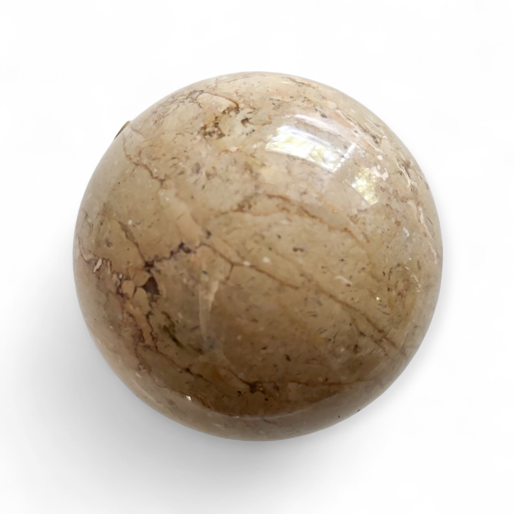 Front view of large polished beige marble sphere