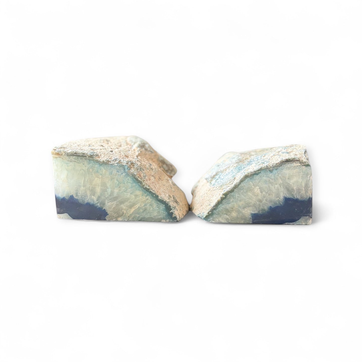 Polished edge of tall blue agate bookends with shimmering crystal and deep navy center.