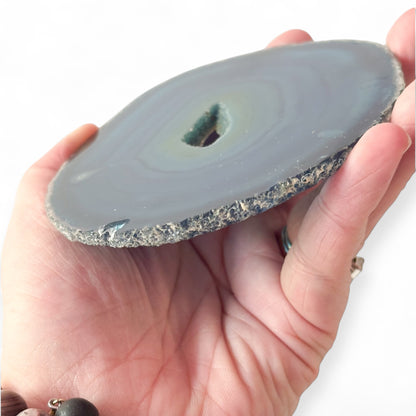 Angled view of blue agate slice with layered crystal bands and raw center