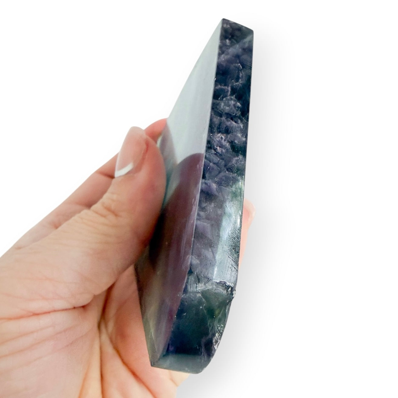 Blue Green Rainbow Fluorite slab held in hand, highlighting aqua, teal, and purple banding.
