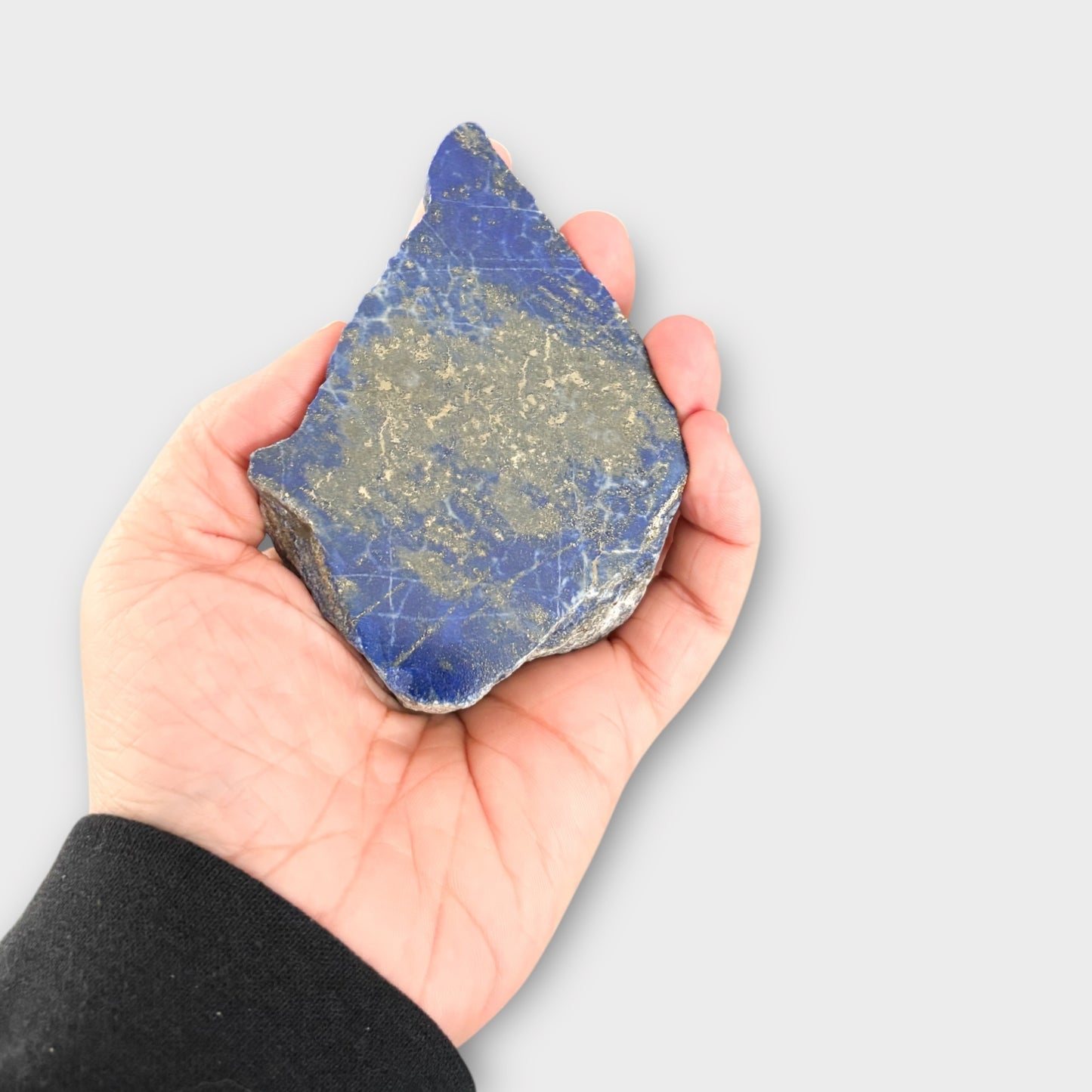 Blue Lapis Lazuli slab resting in palm, showing its size and polish