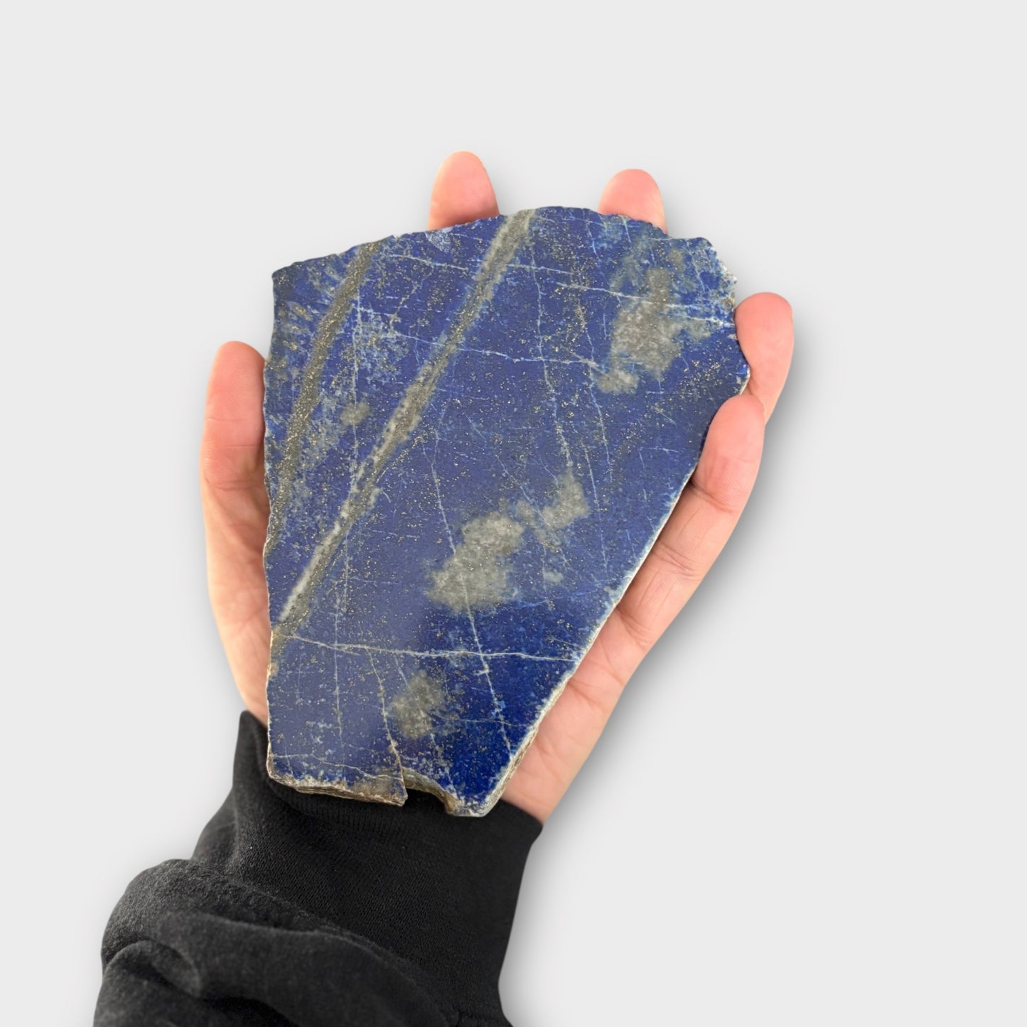 Hand holding Blue Lapis Lazuli slab showing size and smooth polish