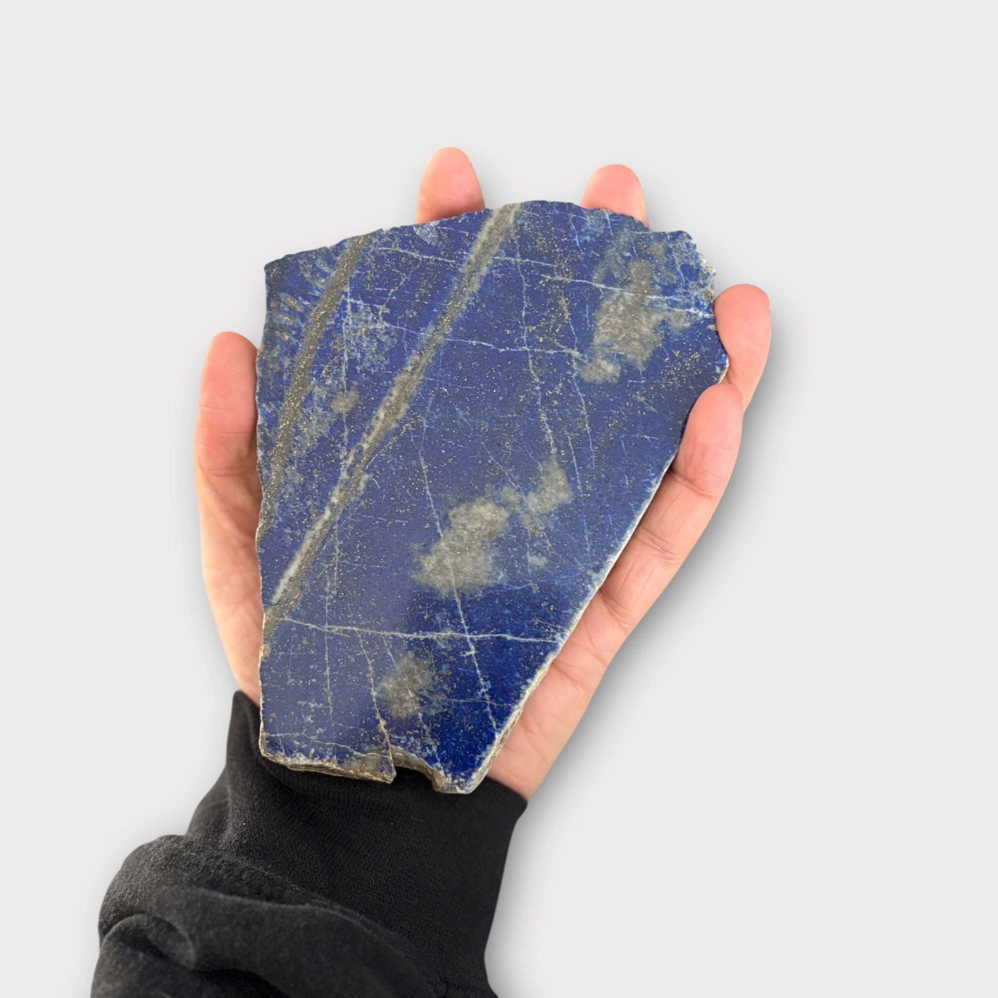 Hand holding Blue Lapis Lazuli slab showing size and smooth polish