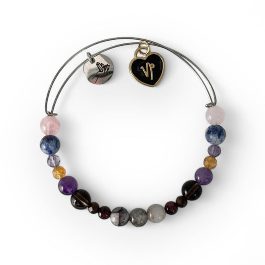 Capricorn Crystal Charm Bracelet with a black charm, featuring Garnet, Tiger’s Eye, Smoky Quartz, Amethyst, Citrine, and Fluorite for determination and grounding.