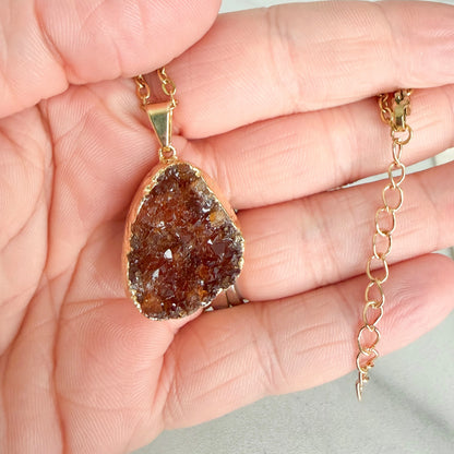 Close up of citrine drusy cluster showing natural crystal sparkle, texture, and gold plated edge detail.