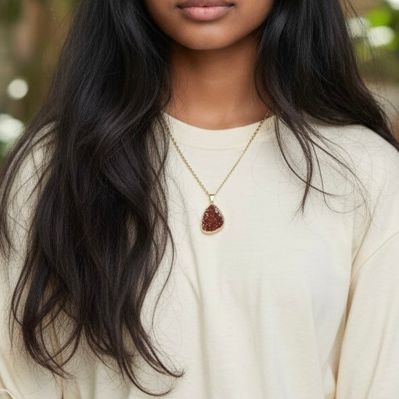 Modeled view of a gold plated citrine drusy cluster pendant necklace on a PVD gold plated stainless steel chain, shown in an AI generated lifestyle image.