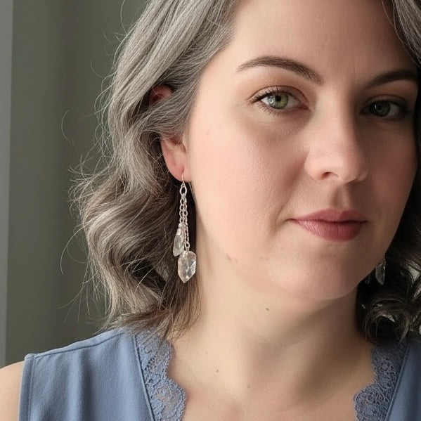 AI model wearing clear quartz dangle earrings with silver plated hardware, showcasing elegant crystal drop style