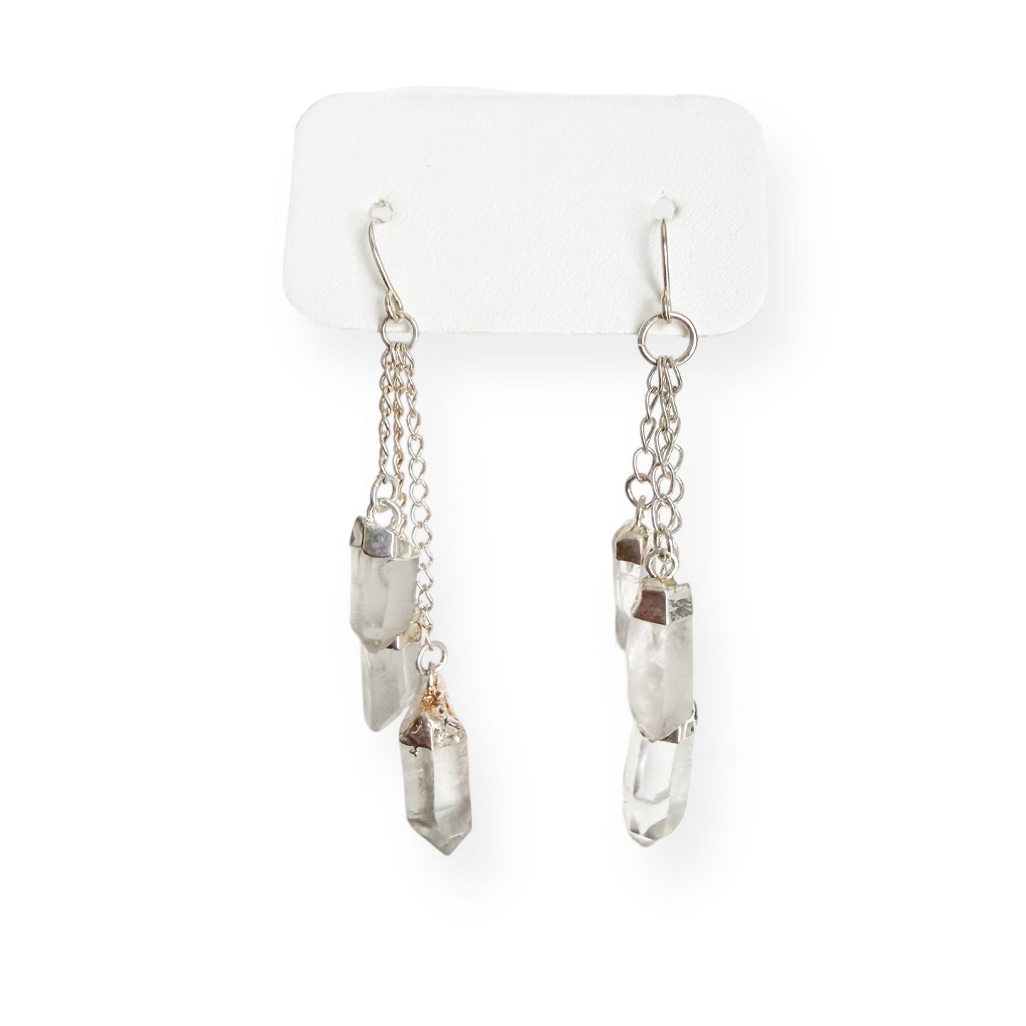 Close-up of clear quartz dangle earrings showing natural crystal texture and silver plated findings