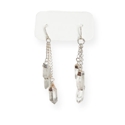 Close-up of clear quartz dangle earrings showing natural crystal texture and silver plated findings