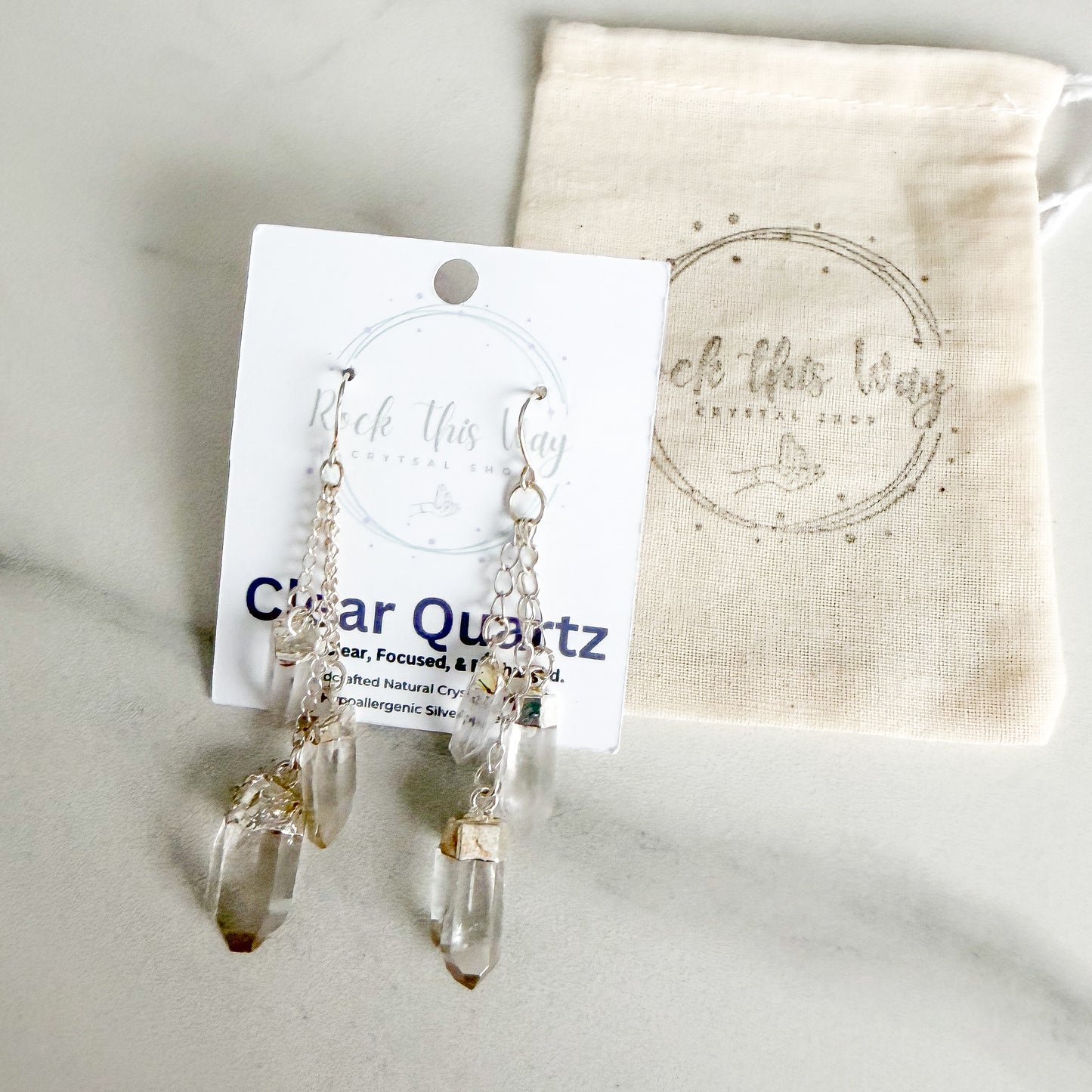 Clear quartz dangle earrings packaged on Rock This Way Crystal Shop jewelry card, ready for gifting