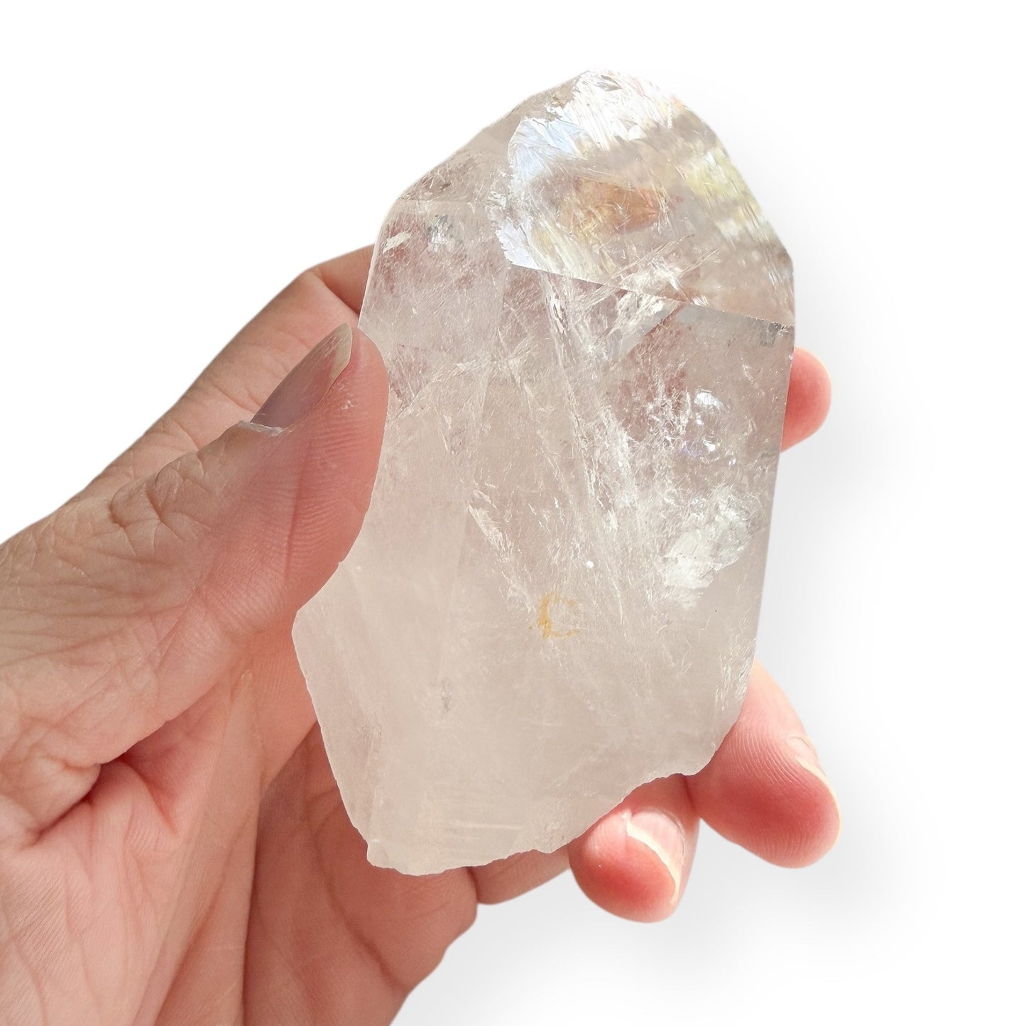 Hand holding raw Clear Quartz Point showing clarity and natural inclusions