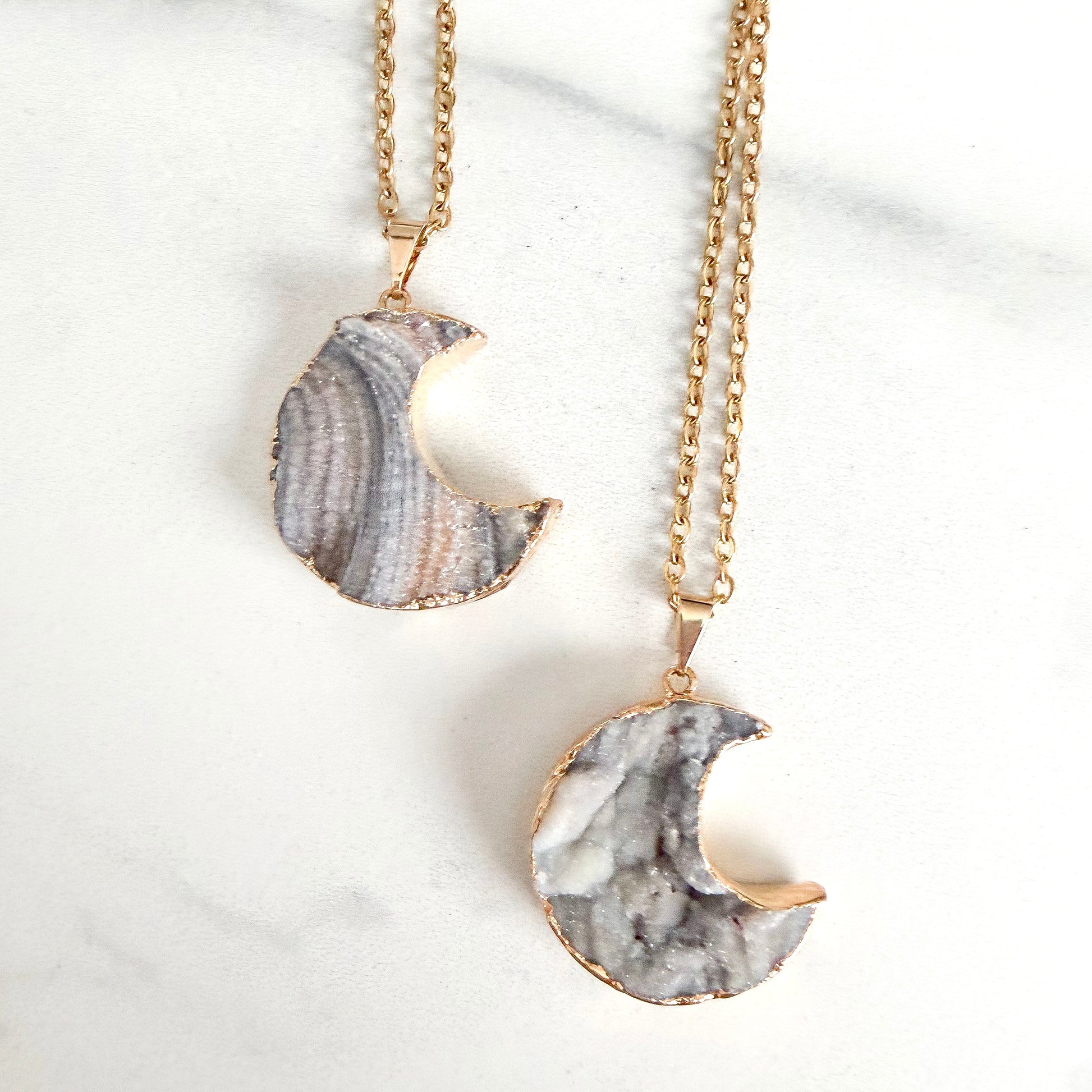 Close up of gold plated crescent moon drusy pendant highlighting natural crystal sparkle and texture.