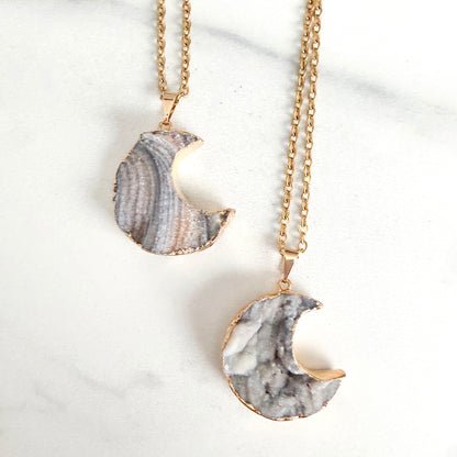 Close up of gold plated crescent moon drusy pendant highlighting natural crystal sparkle and texture.