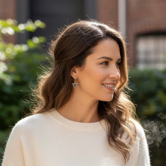 Woman wearing dark triangle drusy huggie earrings with gold filled hoops, featuring small black drusy crystal triangle drops.