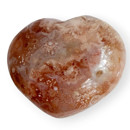 Polished Madagascar Flower Agate heart featuring cream floral plumes, orb-like chalcedony formations, and soft peach tones.