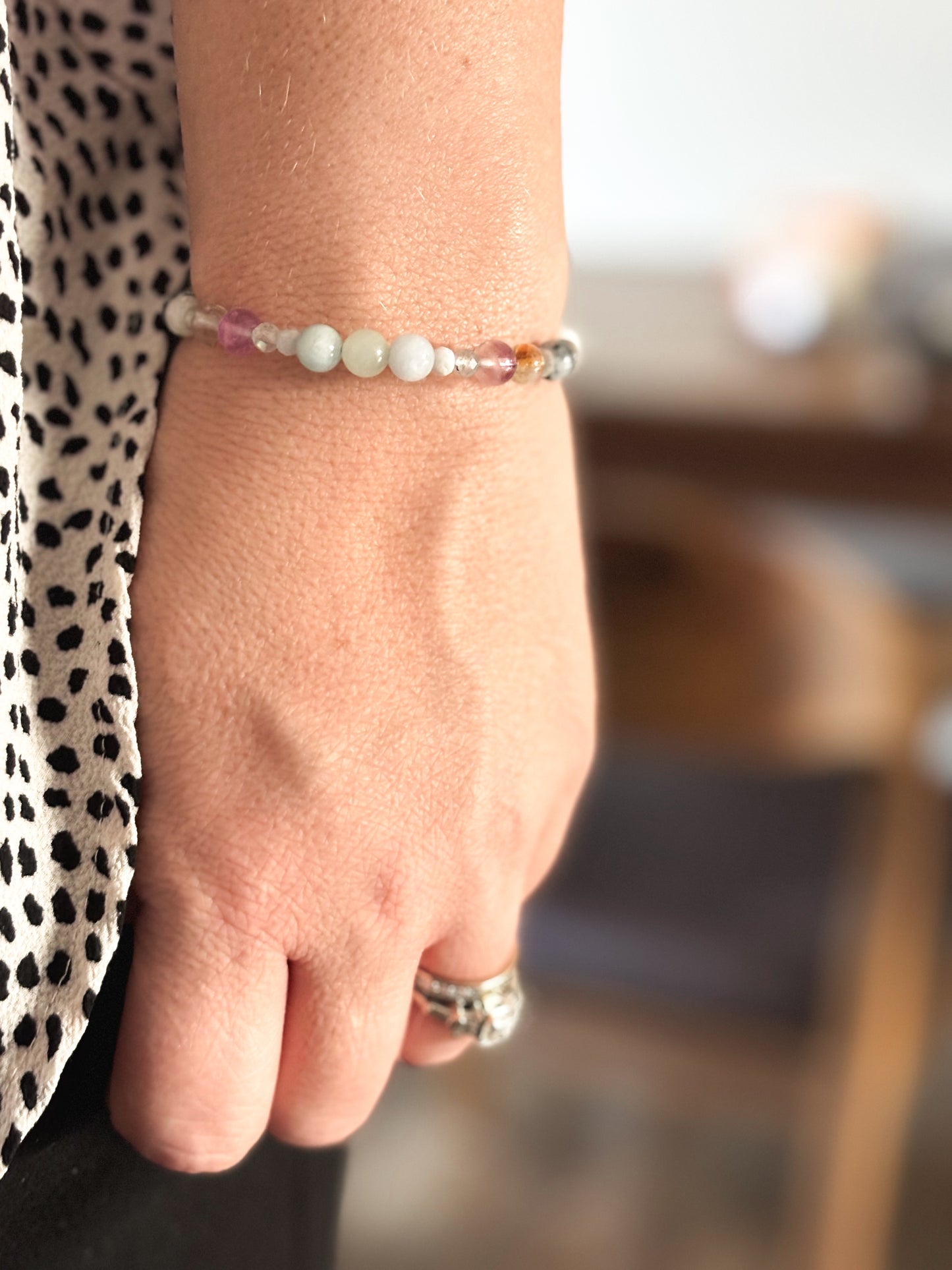 Gemini Crystal Charm Bracelet with a white charm worn on wrist, highlighting its lightweight, flexible fit.