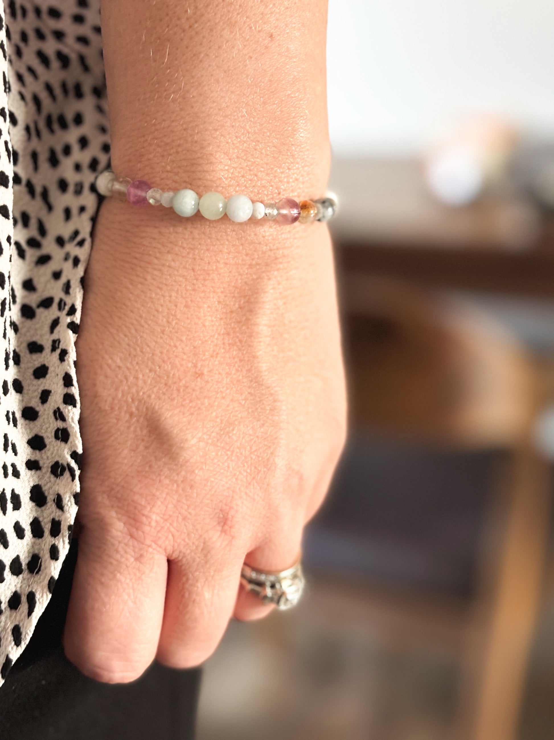 Gemini Crystal Charm Bracelet with a white charm worn on wrist, highlighting its lightweight, flexible fit.